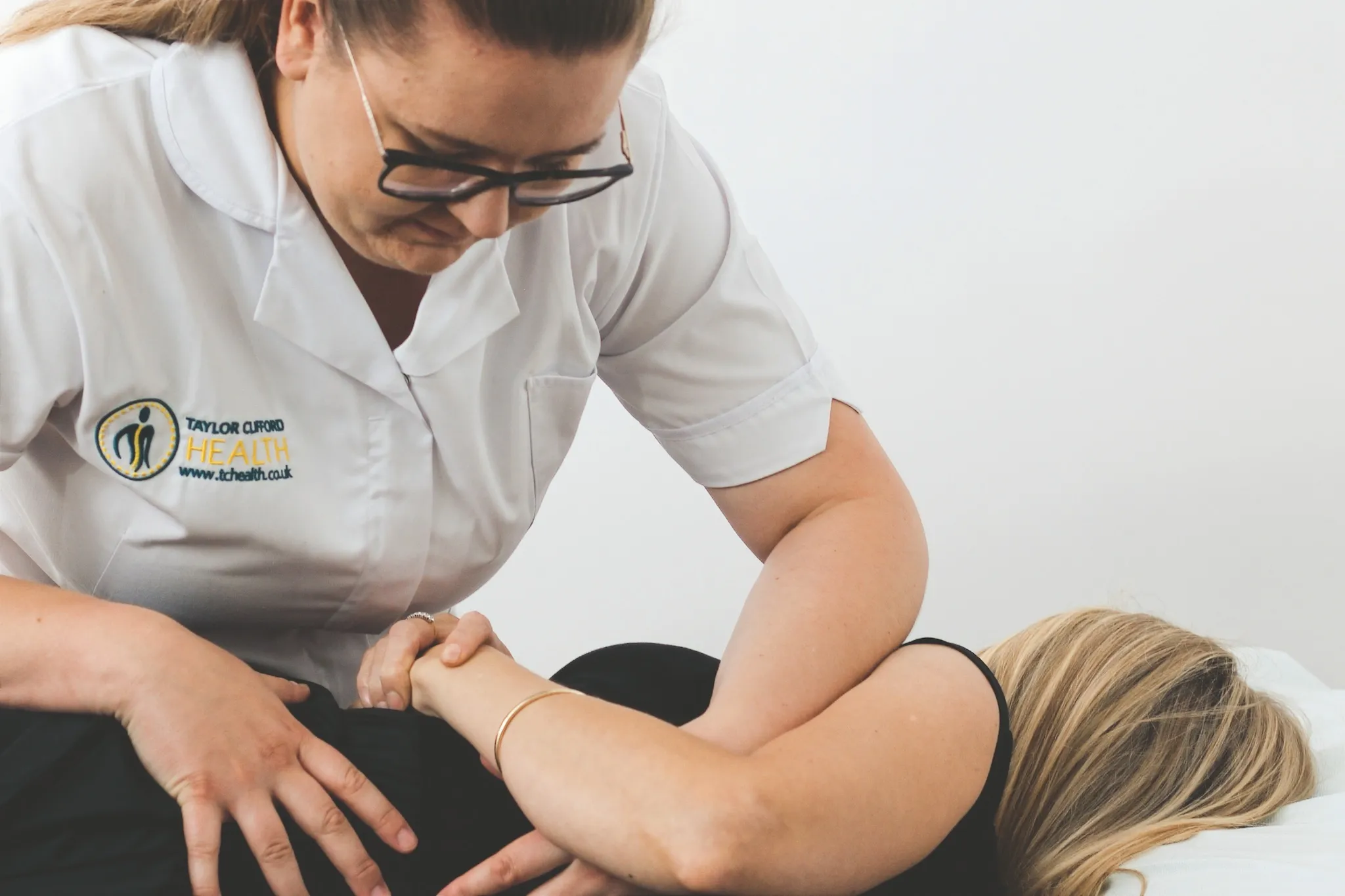 Osteopath performing a lumbar rotation technique for back pain