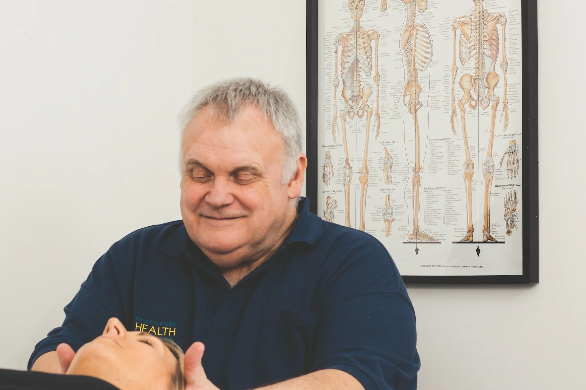 Osteopath supporting a patient's head during cervical treatment for neck pain