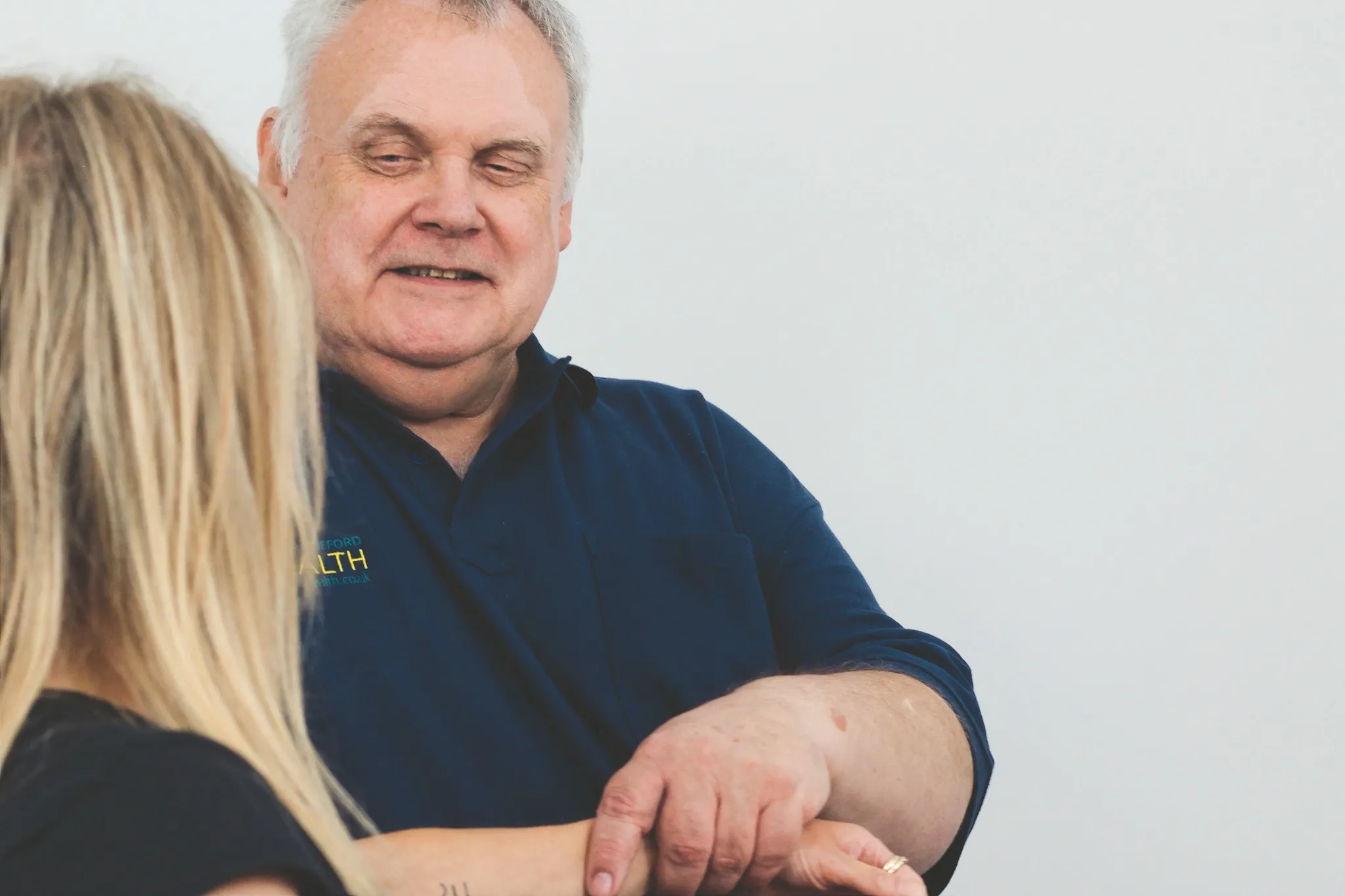 Osteopath assessing a patient's shoulder and arm movement